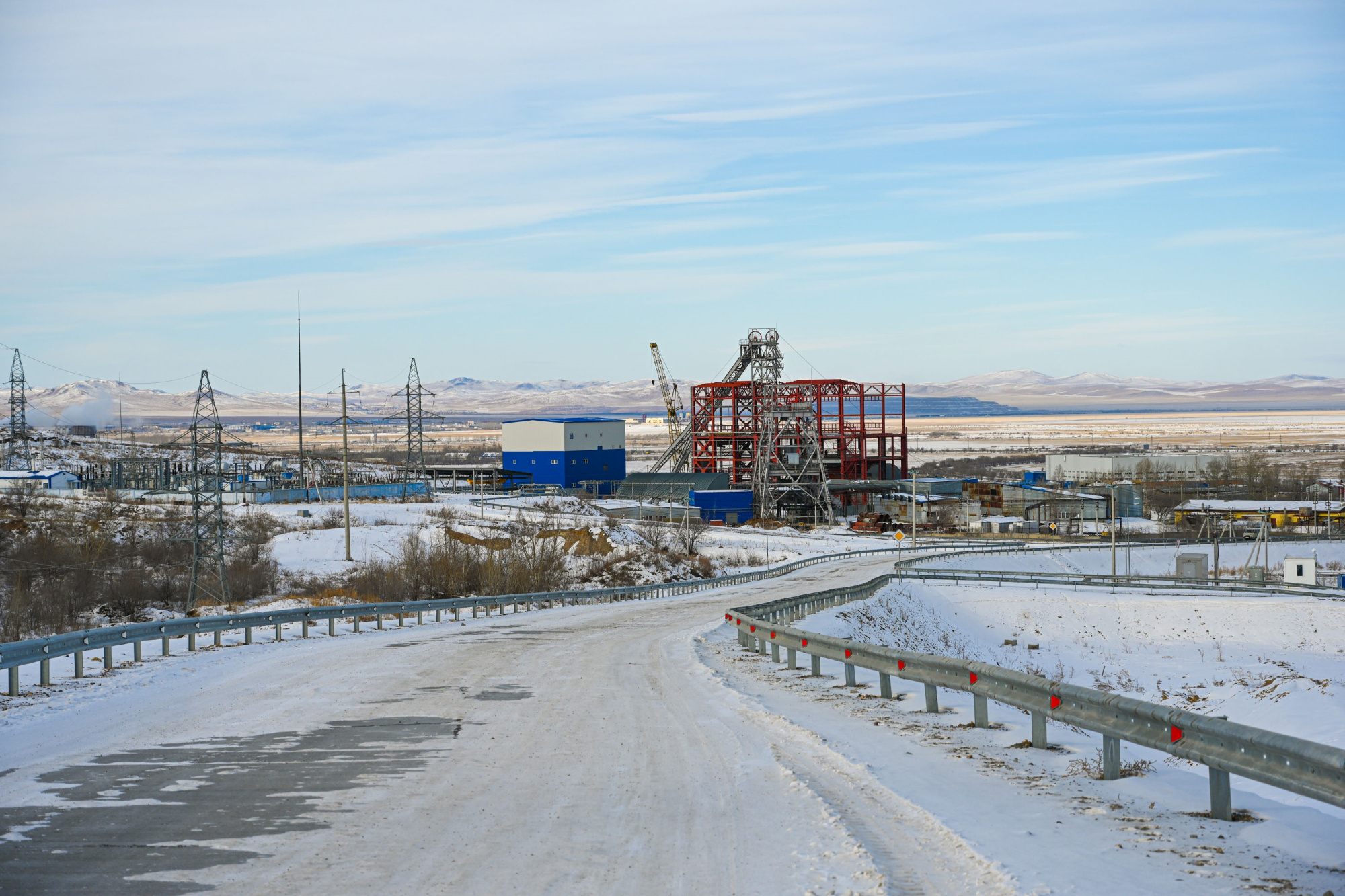PPGHO Mine No. 6 surface site with a shaft headframe and pithead buildings against the hills of Zabaykalsky Krai